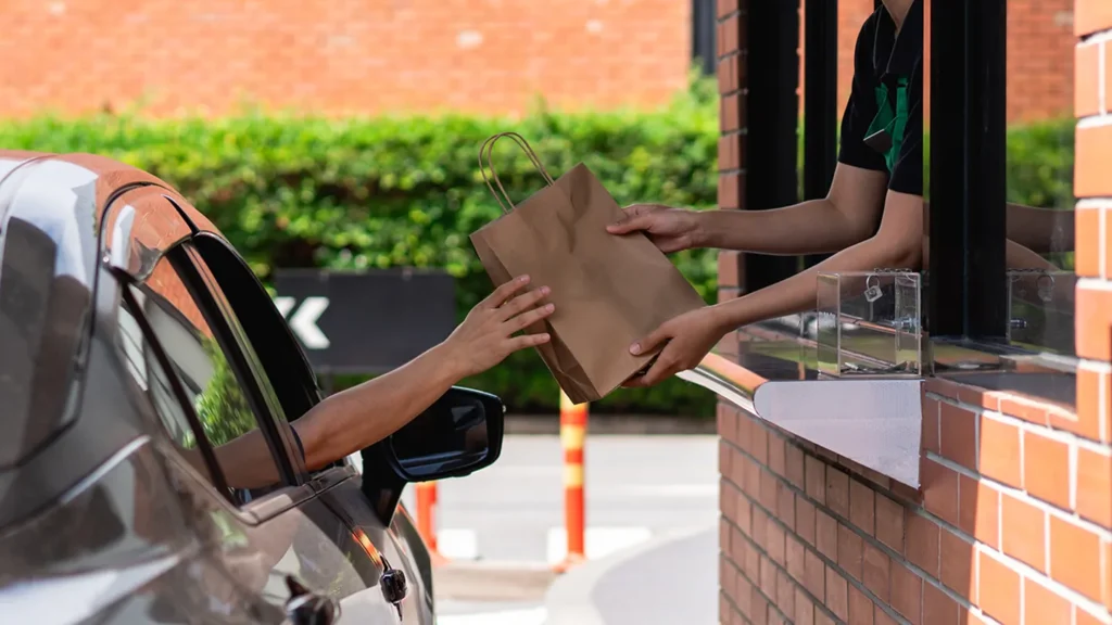 fast food drive thru handing bag of food